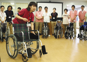 全員必須の入社時研修で、講師（手前）から車いすの基本操作を学ぶＳＯＭＰＯケアグループの職員ら＝東京都港区で