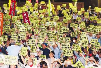 集会で高度プロフェッショナル制度反対などを訴える人たち＝２２日夜、東京都千代田区の日比谷公園で
