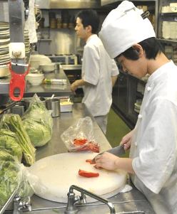 野菜を手早く切る大渡三博さん（右）。働くきっかけとなったのは職場実習だ＝名古屋市昭和区で