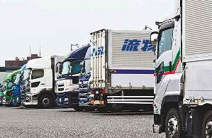 車内で運転手が休憩している大型トラックの駐車場。労働環境の改善は急務だ＝名古屋市港区で（一部画像処理）