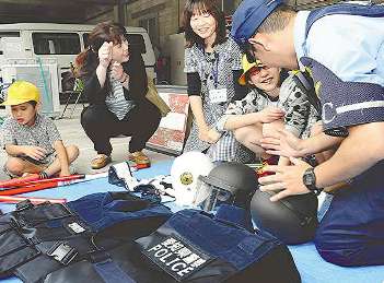 警察官の帽子に触れる児童ら