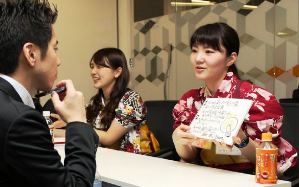 エー・ピーカンパニーが主催した会社説明会で、バイト先のユニホームで採用担当者㊧に自己ＰＲをする学生たち＝東京都港区の同社で