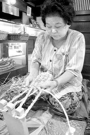 わら草履を作る小野君子さん＝豊田市の「三州足助屋敷」で