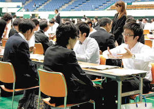 企業の担当者の説明を熱心に聞く参加者たち＝名古屋市中区の県体育館で