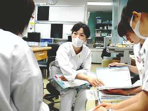 他の看護師と情報交換をする長谷川亜里美さん（中）＝豊橋市民病院で