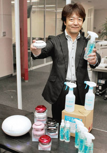 天然由来の薬品を使った洗浄剤や空気清浄機などを手にする波多野社長＝岐阜県多治見市小名田町のアルケミで