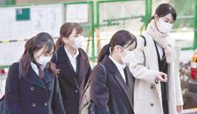 マスク姿で合同会社説明会の会場に向かう就職活動の学生ら＝１日、東京都港区で