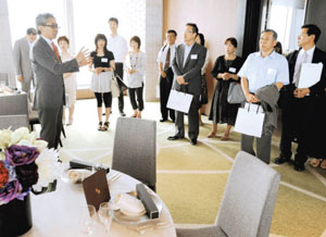 内定者の家族に自社の施設を案内するポジティブドリームパーソンズの杉元崇将社長（左手前）＝東京都港区で