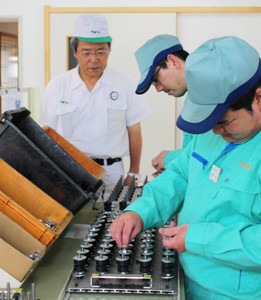 入所者の自動車部品の組み立て作業を見守る板津さん（左）＝美濃加茂市森山町のワークショップむくのきで