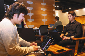 共用オフィスで他の利用者にまじってパソコンに向かう石原怜さん（左）＝千葉県柏市で