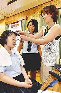 講師（右）の指導でヘアメークを体験する参加者＝北区柳原の市青少年交流プラザで
