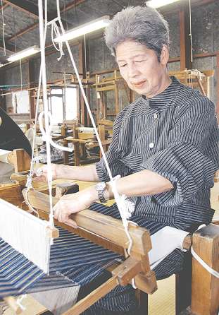 三河木綿の手仕事の伝統を守ろうと機織りに励む高木宏子さん＝岡崎市明大寺町で