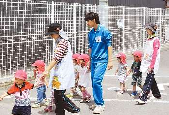 園児と手をつなぎ散歩する山県高の生徒(中)＝山県市高富の高富保育園で