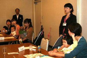 先輩職員（立っている女性）の話を聞く出席者＝松阪市日野町で