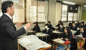 堀英彦教諭(左)の指導で新聞の活用法を学ぶ生徒たち＝多治見市明和町の多治見西高校で