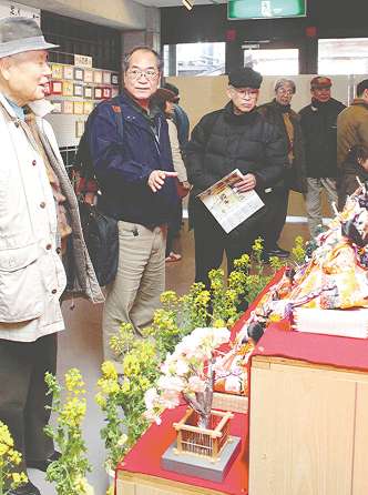 ひな人形の展示会場を案内する鱸さん（中）＝豊田市足助町で