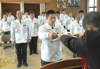 激励文を受け取る宇野雄司さん（中央）＝名古屋市西区の県職業訓練会館で