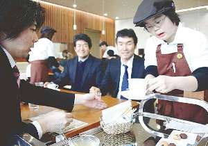 飲み物を客席に置く障害者（右端）＝豊田市錦町のボンズカフェで