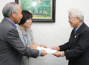 高校生の就職、採用に関する要請書を受け取る県中小企業団体中央会の佐久間会長（右）＝津市の県中小企業団体中央会事務局で