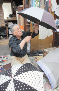 出来上がり具合を確認する傘職人の山崎健次さん＝東京都台東区で