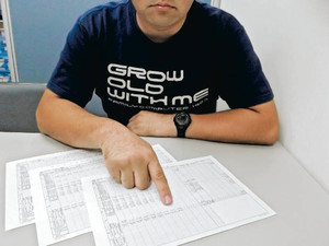 会社が出した賃金台帳を示す死亡した男性の弟。直近３カ月の勤務日数が空白になっている＝東京都内で
