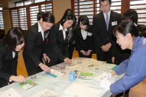 職場体験型の説明会で学生に鑑識作業を教える署員（右）＝名古屋・中署で