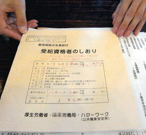 女性が手にする雇用保険の書類。「ハローワークも頼りにならなかった」と話した