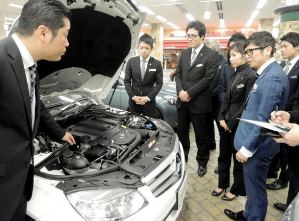 車の基本構造について説明を聞くホワイトハウスの販売員＝愛知県東郷町のオートプラネット名古屋で