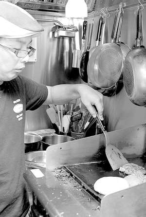 パティの焼き上がりを計算しながら作業をする菊地さん＝豊田市西町１のアメリカンバー「ＡＭＥＲＩＣＡＮＯ」で