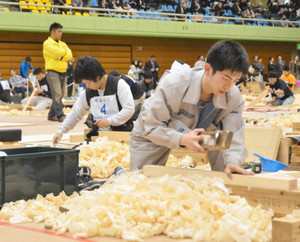 「建築大工」の競技で、かんなを使って角材の表面を削る選手たち＝豊橋市総合体育館で