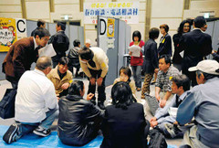 「春の面談・電話相談村」で相談に訪れた人たちの話を聞くボランティアや実行委員ら＝８日、東京都新宿区の日本青年館で