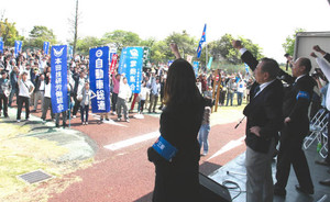 処遇改善や格差是正を求めて気勢を上げる参加者＝津市の鈴鹿サーキットで