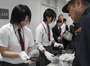 ビンについた指紋の採取を体験する参加者＝県警本部で