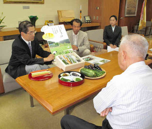 採れた野菜を披露する四十万谷社長（左）ら＝金沢市役所で