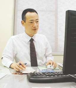 パソコン画面に向かって給与計算をする渡辺裕一郎さん＝豊川市下野川町の事務所で