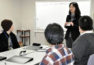 孫さん（右から２人目）の話に耳を傾ける参加者＝伊賀市上野中町の上野ふれあいプラザで