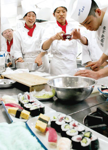 すし職人の包丁さばきを学ぶ生徒ら＝津市の三重調理専門学校で