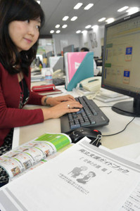 社内サイトに載せた両立支援のガイドブックを見る篠原宏美さん＝名古屋市西区のトヨタファイナンスで