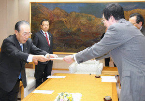 要請文を川田達男・県経済団体連合会長に手渡す福田優・県大学連携リーグ会長（右）＝福井市で