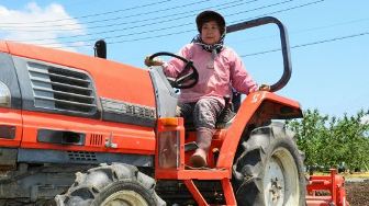 トラクターで畑を耕す宮沢信代さん＝長野市上駒沢で
