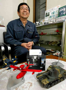 細部まで精巧に再現された戦車や飛行機などのプラモデルを前にモノづくりへの思いを語る鈴木邦宏社長＝愛知県豊橋市のファインモールドで