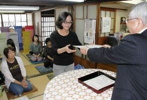 竹田嘉兵衛さん(右)から修了証を受ける高橋さん(中)ら修了生＝緑区有松の県絞工業組合で