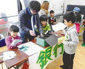 子どもの町の「銀行」で取引する子どもたち＝半田市の向山公民館で