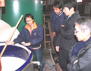 中島専務（左）から酒造りの工程を学ぶ会員ら＝土岐市駄知町の千古乃岩酒造で