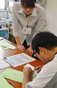 就労を目指し、生活指導員のサポートで作業訓練に励む精神障害のある人（手前）＝愛知県瀬戸市の「仕事ノアル暮らし」で