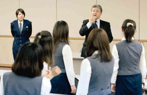 女性社員にひったくりなど犯罪の防止を呼び掛ける警察官＝４月、名古屋市中川区の企業で