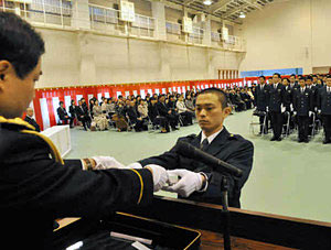斉藤県警本部長（左）から辞令を受け取る藤田巡査＝富山市向新庄町で