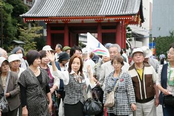 長年の蓄積を生かしながら観光地を案内する加藤愛恵さん（中央）＝東京都台東区の浅草寺で