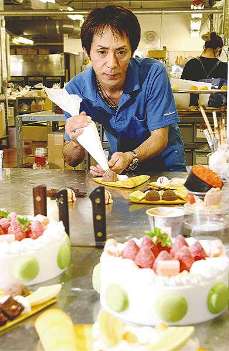 樹脂製の“生クリーム”で飾り付けをする畑佐伸一郎さん＝横浜市鶴見区で