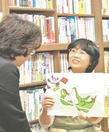 お客さんとじっくり話しながら紙芝居を薦める浅井洋子さん（右）＝岡崎市の「ちいさいおうち」で